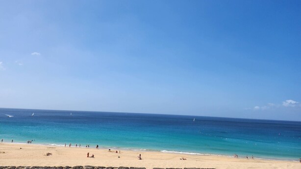 A beach with clear skies, calm water, and people enjoying the shore. - Casa Del Sol Rio in Costa Calma (Costa Calma)