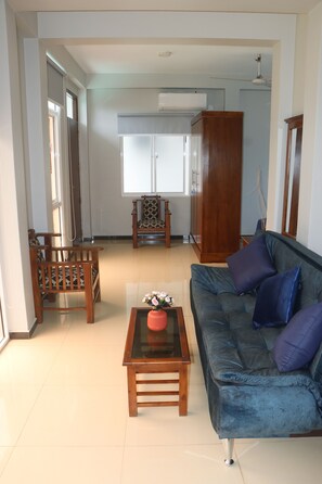 A living room with a sofa, a wooden table, and a cabinet. - Kumatha Residence, Ground Floor one bedroom  apartment ,350m to beach /pool view (Negombo)