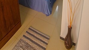 Ein Schlafzimmer mit einem Bett, einem Nachttisch, einem Fenster und einer Tür.