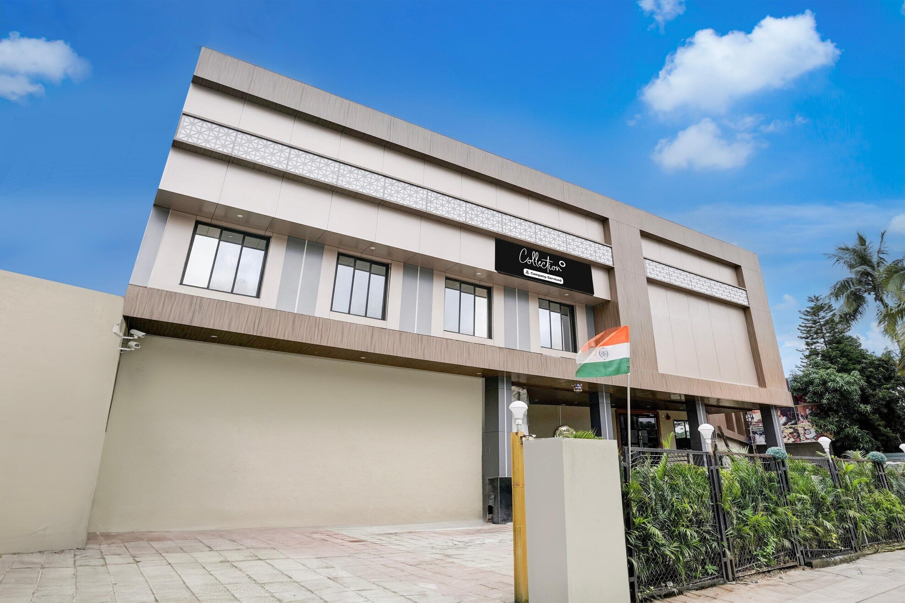 A modern building with a sign reading 'Collection,' a flag, and a gated entrance.