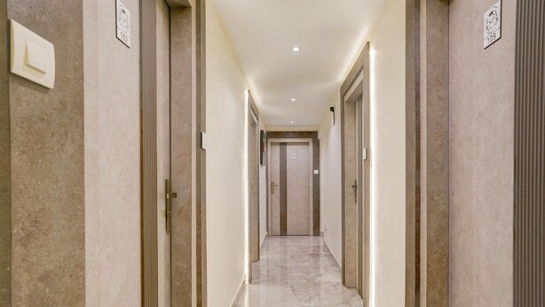 A corridor with marble flooring, doors on both sides, and recessed lighting. - Super Collection O Ghodbunder Road (Mumbai)