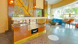 A reception desk with a 'RECEPTION' sign, a 'TOWNHOUSEOAK' sign, and a blue sofa in the background. - Deluxe With Twin Bed Sitabuldi Station (Nagpur)
