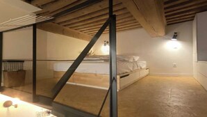 Um quarto com cama, janela e luminária.