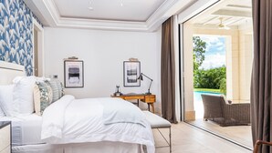 Un dormitorio con cama, escritorio y vista a una piscina.