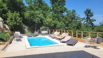 Zona de piscina amb gandules i un tobogan.