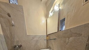 A bathroom with a shower, sink, toilet, and a mirror. - Experience Royal Living in a Heritage Haveli (Jaipur)