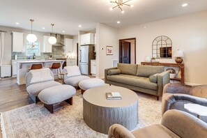 A modern living room with a round coffee table, two sofas, and a kitchen in the background. - 3 Mi to New River Gorge NP! Rafting & Hiking Hub (Fayetteville)