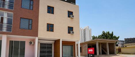 A hotel with a modern design, featuring a prominent 'OYO Hotel' sign, a brick facade, and a flat roof.