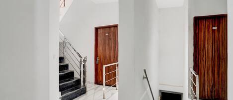 A staircase with a handrail, a wooden door, and a metal gate.