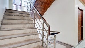 A staircase with metal railings and wooden steps, leading to a door with a wooden panel. - Collection O Kanpur Domestic Airport (Kanpur)
