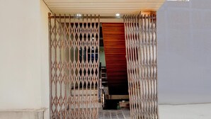 A doorway with a metal gate and a red wall behind it. - Collection O Kanpur Domestic Airport (Kanpur)