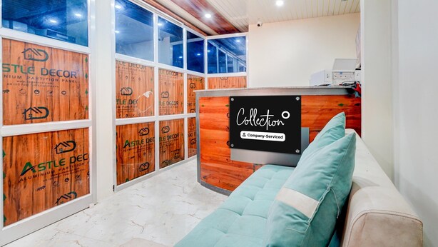 A room with a wooden partition wall, a reception desk, and a sofa. - Collection O Kanpur Domestic Airport (Kanpur)