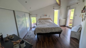 Une chambre à coucher avec un lit, un bureau, un radiateur et une fenêtre.