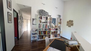 Une pièce avec un plancher en bois, un bureau recouvert de papiers, une bibliothèque et une décoration murale sur le thème de Star Wars.
