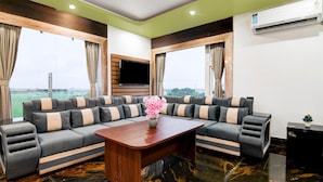 A modern living room with a sectional sofa, a wooden coffee table, and a flat-screen TV.