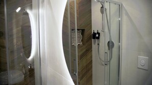 Ein modernes Badezimmer mit Duschkabine aus Glas, einem weißen Waschbecken und einer dekorativen Wandverkleidung.
