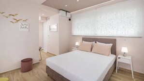 Una camera da letto moderna con un letto grande, comodini, condizionatore d'aria a muro e una parete decorata.