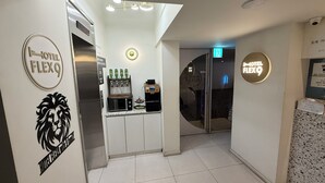 A hotel lobby with a reception desk, a minibar, and a glass door leading to the rooms. - Flex9 (Uijeongbu)