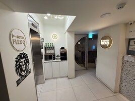A hotel lobby with a reception desk, a minibar, and a glass door leading to the rooms.