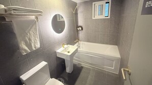 A bathroom with a toilet, sink, and bathtub. - Flex9 (Uijeongbu)