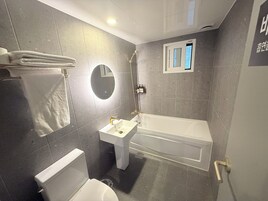 A bathroom with a toilet, sink, and bathtub.
