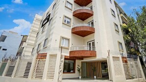A multi-story building with balconies, a gated entrance, and a clear sky. - Deluxe Banaras Central Railway Junction Sri Hari Inn (Varanasi)