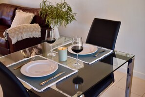 A dining table set with plates, cutlery, wine glasses, and a candle.