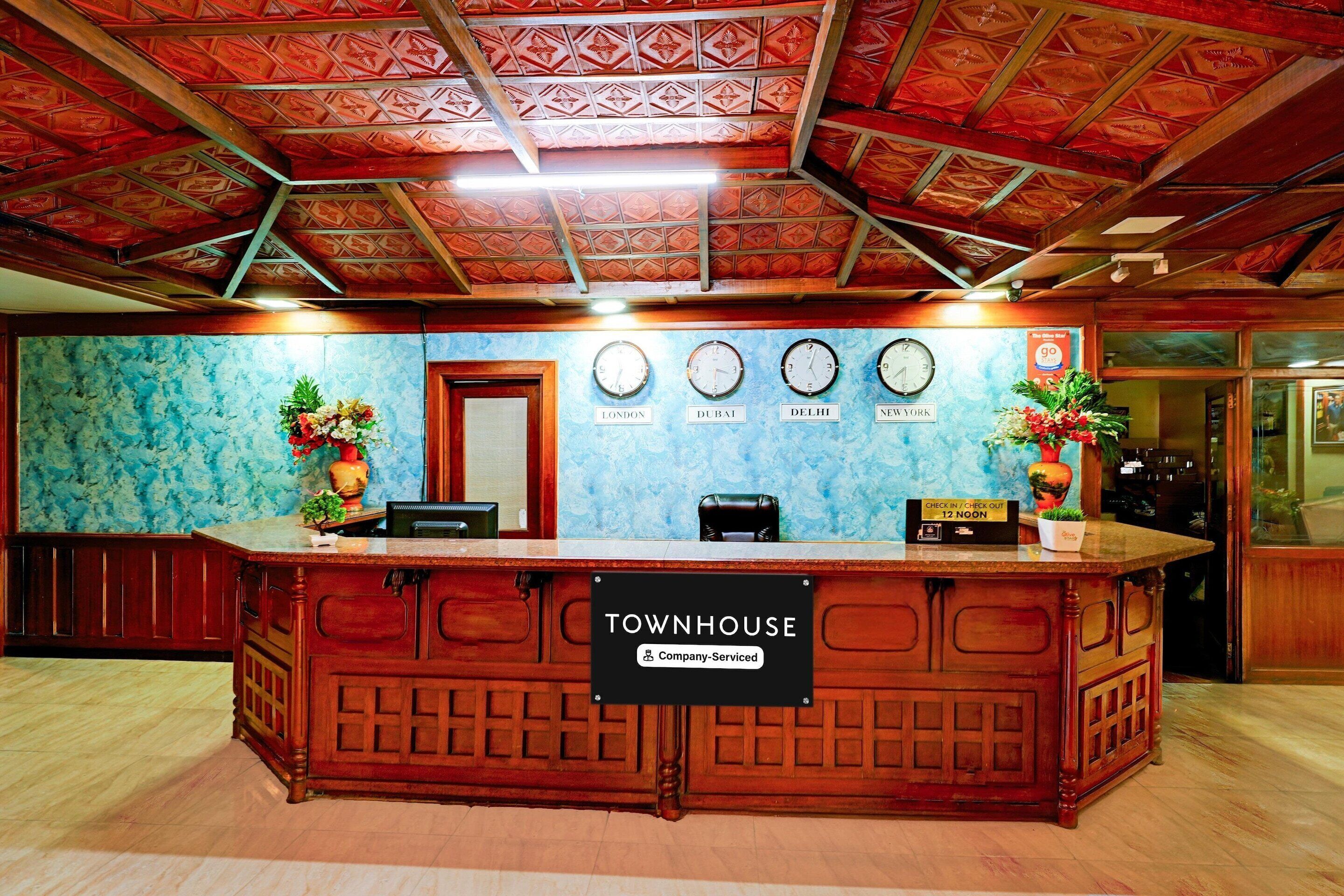 A reception desk with a sign reading 'TOWNHOUSE' and 'Company-Served.'