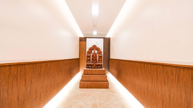 A narrow hallway with wooden paneling and a central staircase leading to a small shrine. - Deluxe Pallette Shree Jagannatha Puri Lotus (Puri)