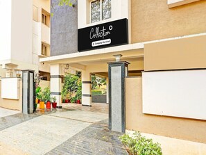 A building entrance with a sign reading 'Collection,' potted plants, and a tiled pathway. - Premium Collection O Beach Near Gitam (Visakhapatnam)
