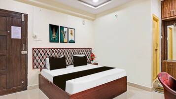 Quarto com cama de madeira, cabeceira estampada e porta com um aviso.