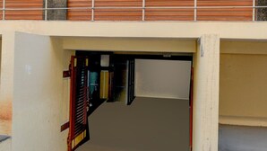 A building entrance with a metal gate, a stairway leading down, and a concrete floor. - Super Collection O Forum Mall Hyderabad (Hyderabad)