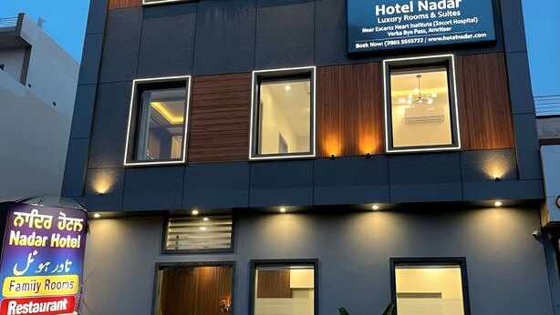 Et moderne hotel med skilt, der angiver luksusværelser og suiter, restaurant og familieværelser.