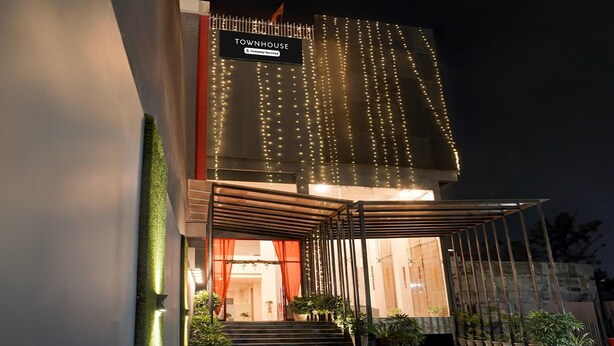 A modern building with a sign reading 'TOWNHOUSE' and a covered entrance with steps leading up to it. - Super Deluxe Room Landmark Hotel (Lucknow)