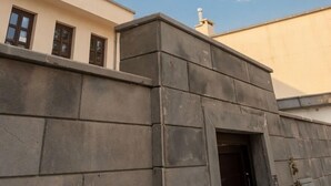 Un edificio con techo plano, una antena parabólica y una chimenea.
