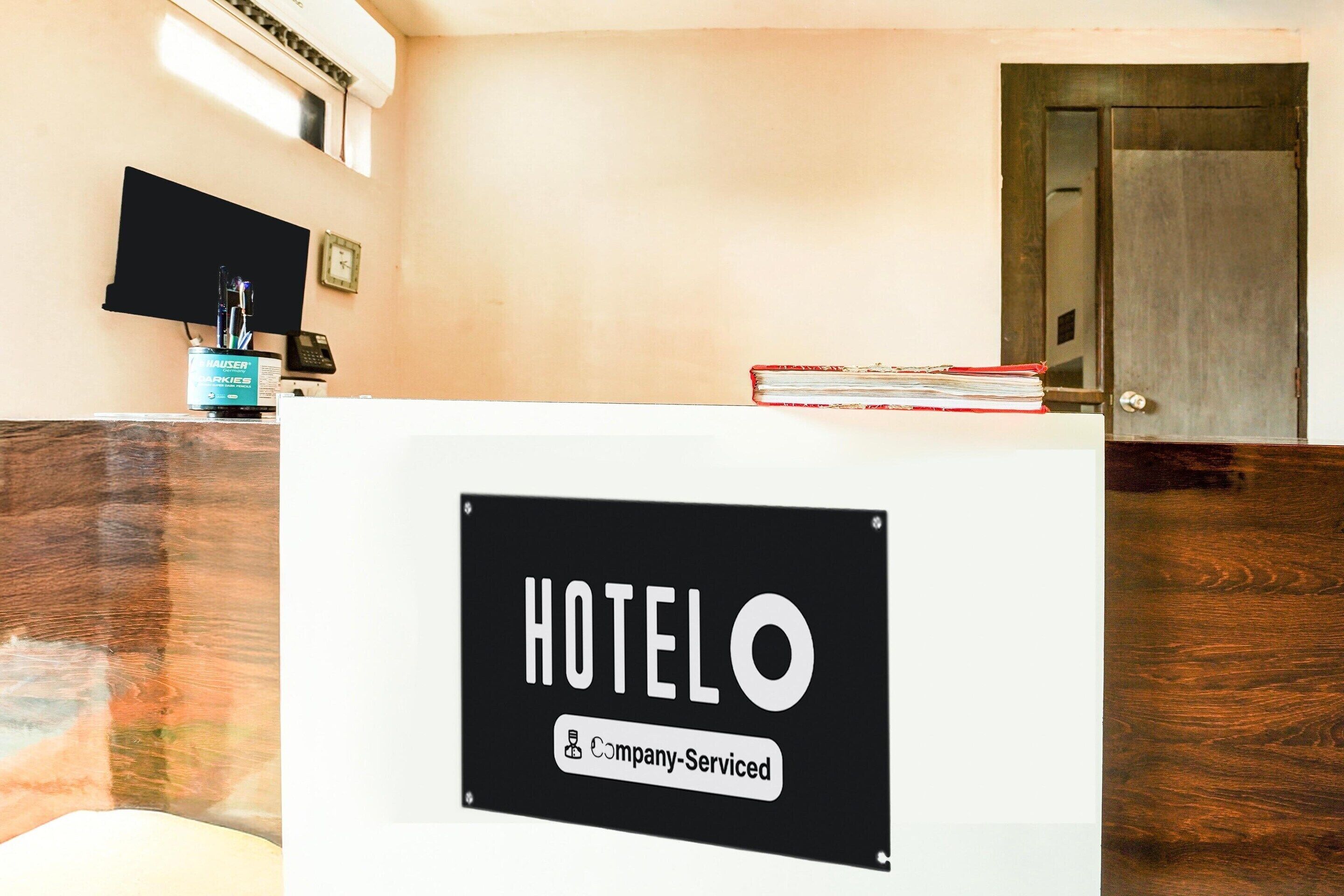 A reception desk with a sign reading 'HOTELO Company-Serviced.'