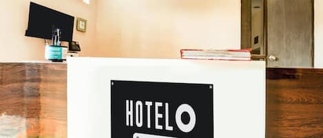 A reception desk with a sign reading 'HOTELO Company-Serviced.'