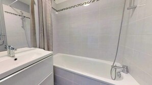 Ein Badezimmer mit Badewanne, Waschbecken und Dusche.