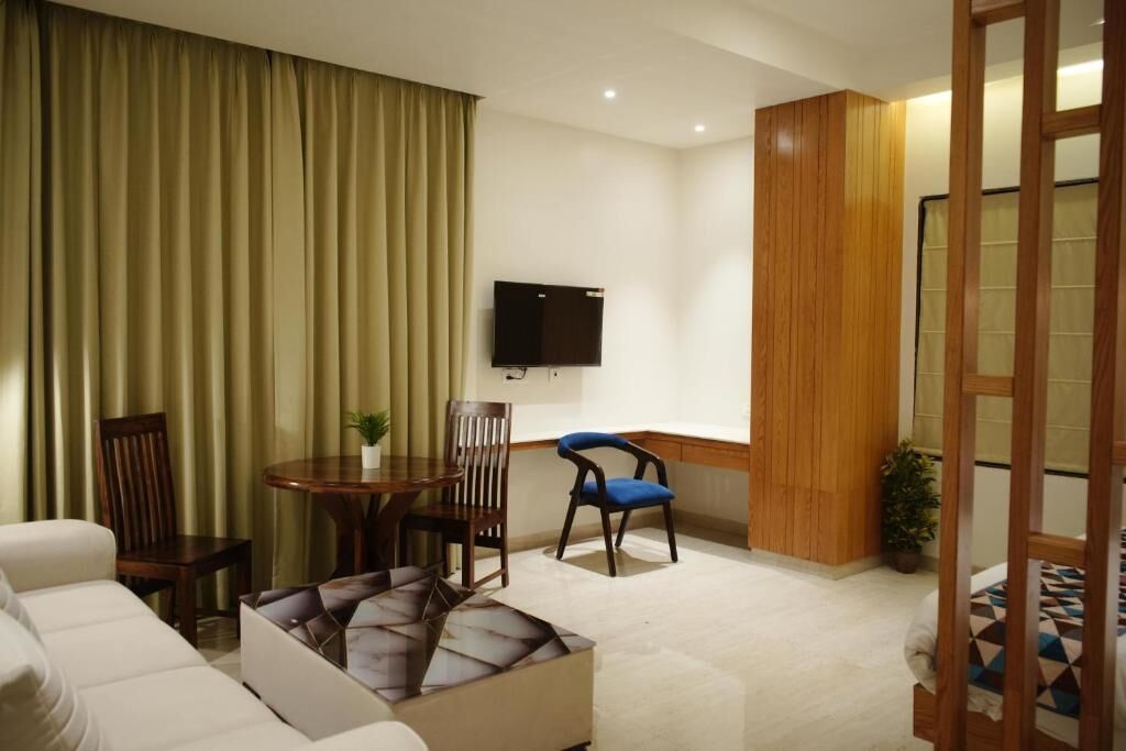 Una sala de estar con un sofá, sillas, una mesa, un televisor y un panel de pared de madera.
