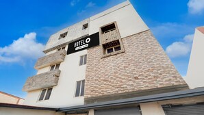 Un hôtel avec une enseigne, une façade en briques et un ciel dégagé.