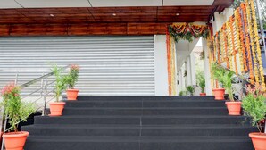 A staircase with potted plants, a closed garage door, and a wooden ceiling.