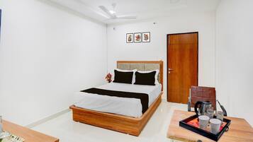 Une chambre bien rangée, avec un lit, une table de chevet et une porte.