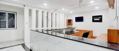 A modern reception area with a marble counter, ceiling fans, and a sign indicating 'TOWNHOUSE OAK & Company Serviced'.