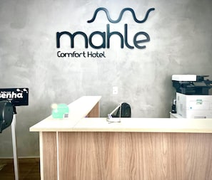 A reception desk at Mahle Comfort Hotel with a sign indicating a parking area. - Mahle Comfort Hotel (CAMPINA GRANDE DO SUL)