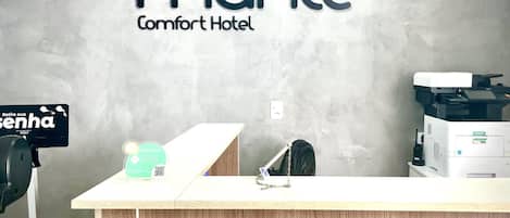 Mostrador de recepción en el Mahle Comfort Hotel con un cartel que indica una zona de estacionamiento.