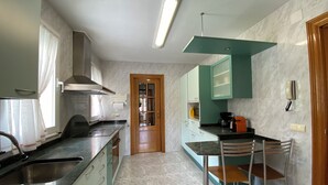 Een moderne keuken met een ingebouwde kookplaat, een spoelbak en een eethoek met stoelen.