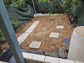 A garden area with mulch, stepping stones, and green plant barriers. - MAISON LA SOURCE; with five bedrooms and garden (Roubaix)