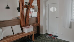A room with a wooden bench, a white door, and a small window. - Villa Gänseblümchen—Vacation Home Near Schwerin, Accessible (Brüsewitz)