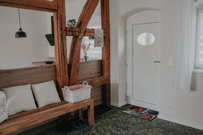 A room with a wooden bench, a white door, and a small window. - Newly renovated vacation home near Schwerin for 2 people, barrier-free (Brüsewitz)