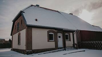 A brick building with a snow-covered roof and a small porch.